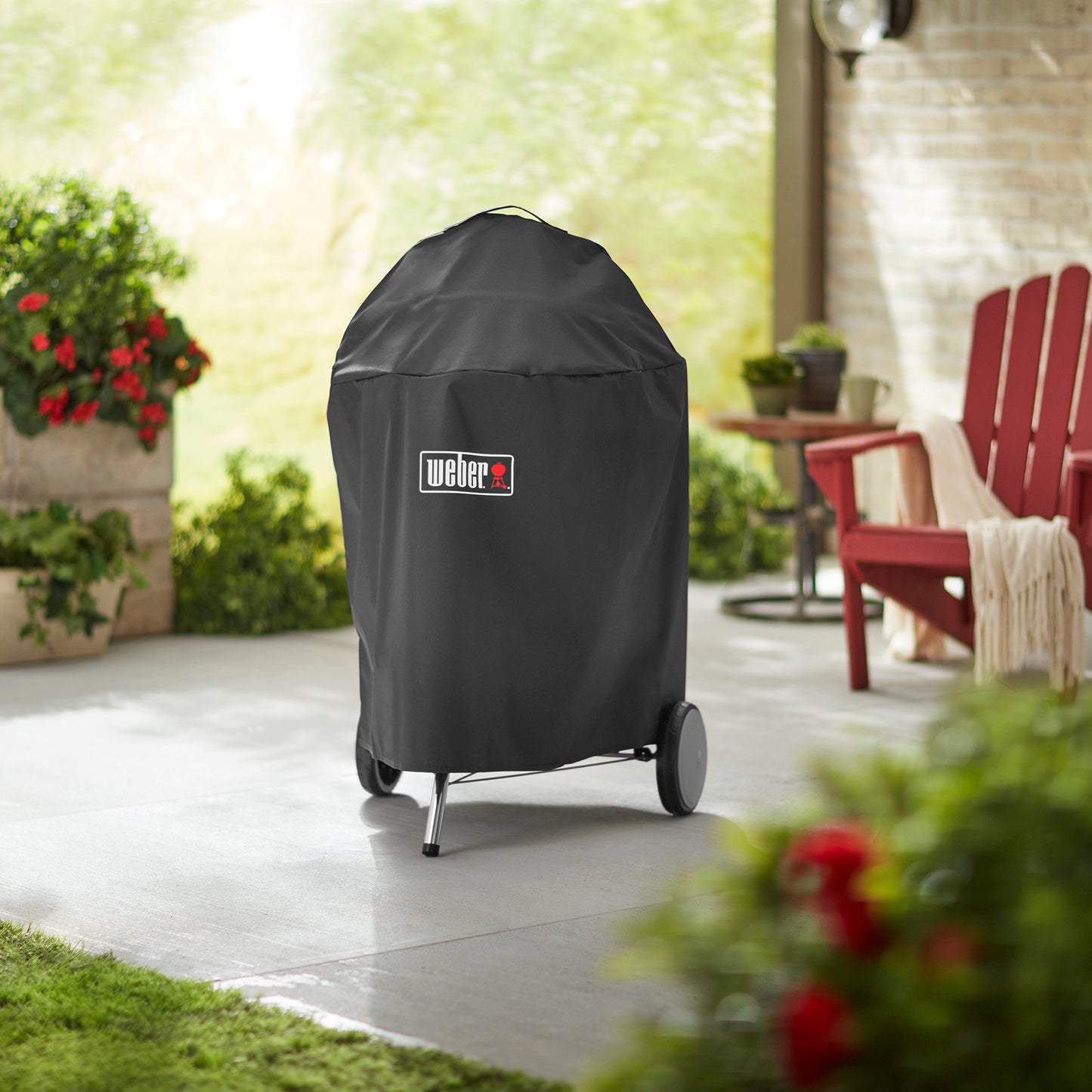 Weber Kugelgrill 57 cm mit aufgesetzter Premium-Abdeckhaube im Garten