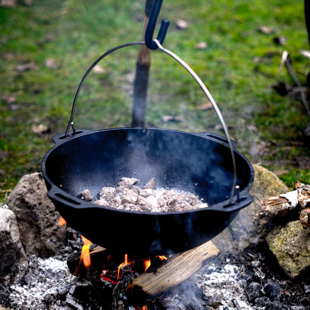 Offener Petromax Kazan beim Kochen über dem Feuer